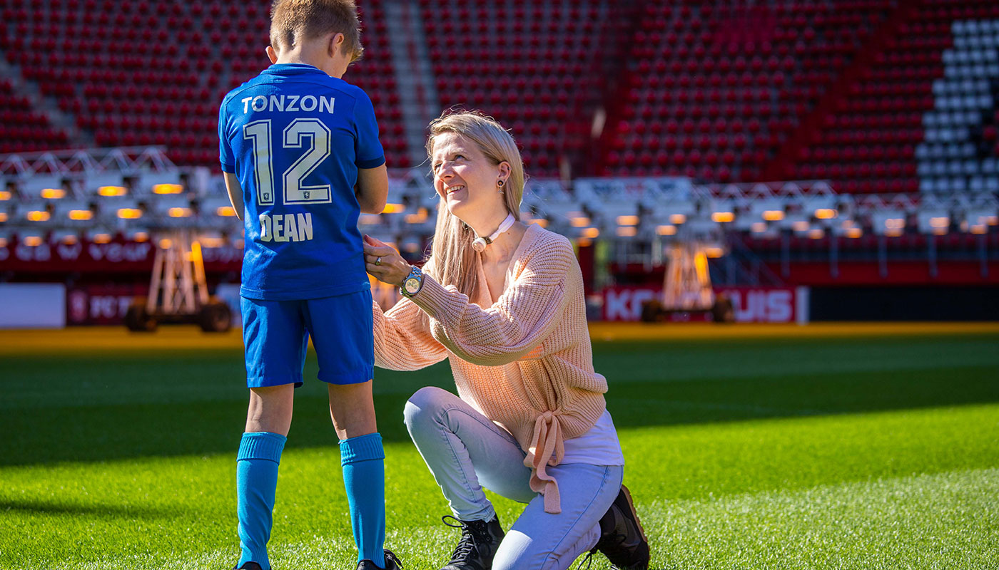 Woman using Freevent DualCare while talking to her son a football field.